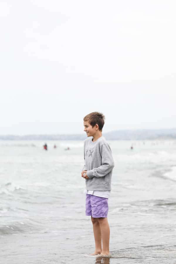 boy playing in the ocean on a gloomy day.