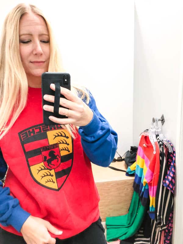 Girl trying on Porsche sweatshirt at a Crossroads Trading store