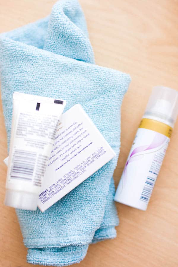 A microfiber towel and some travel sized toiletries laying on a table. 