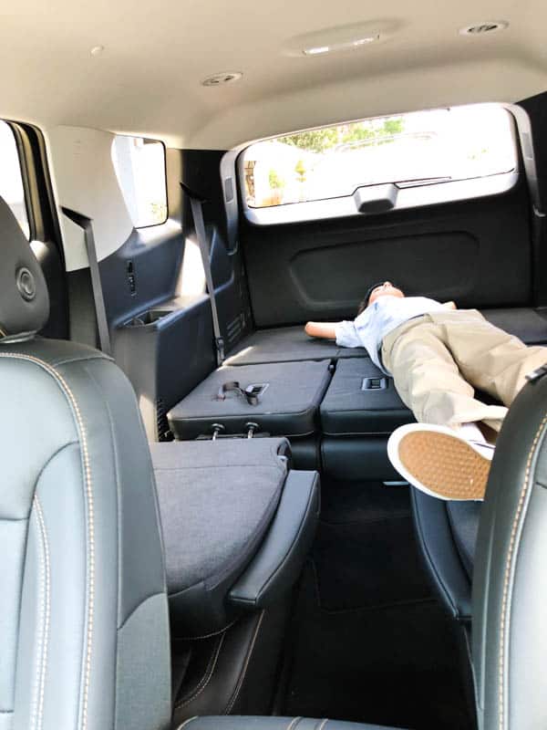 kid laying down in the back of a Chevy Traverse with the seats laid down