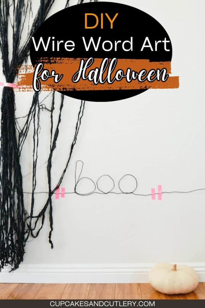 Text: DIY Wire Word Art for Halloween, Boo; black wire is twisted into the word "boo" for a simple Halloween decoration with a white pumpkin on the ground and ripped black fabric on the wall.
