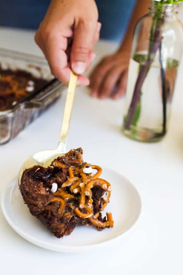 Close up image of a slice of dump Cake for halloween with pretzels and caramel.