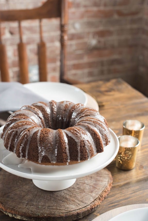 Classic nutmeg bundt cake on a cake plate with icing.