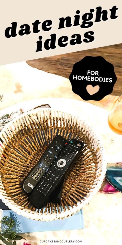 A basket on a coffee table holding remote controls next to a glass of wine.