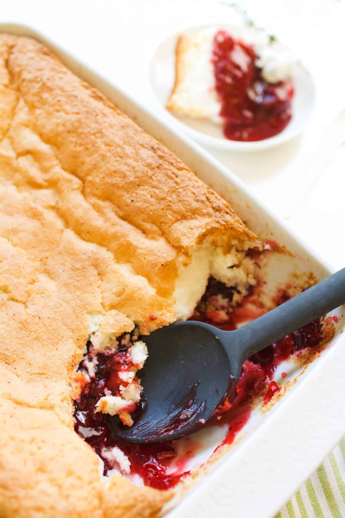 A baking dish with a strawberry dump cake topped with angel food cake.