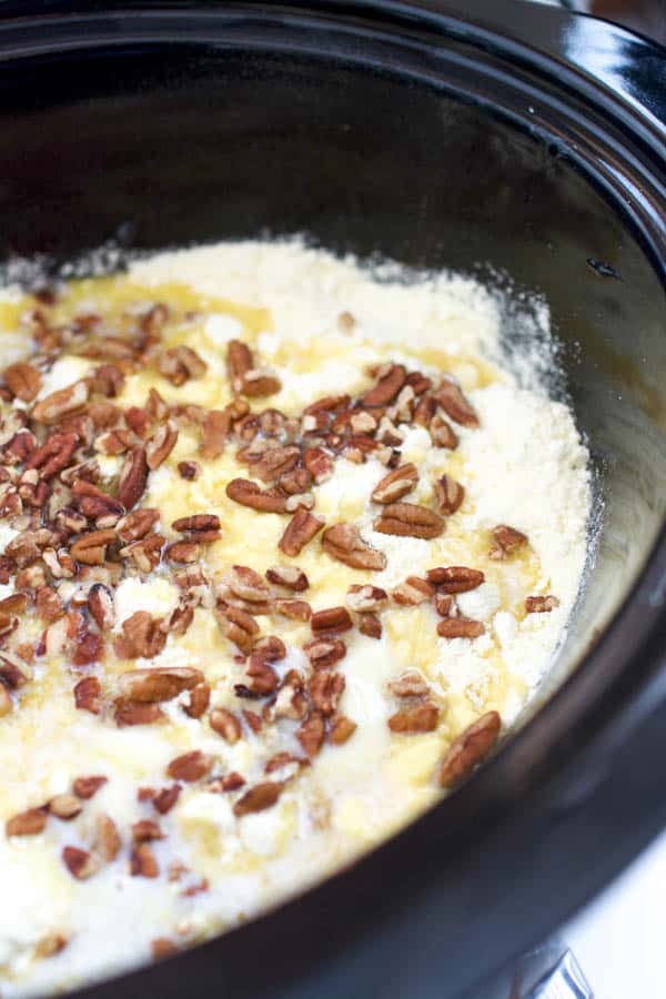 Making apple cherry dump cake in a crock pot with pecans.