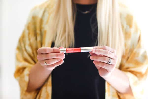 Woman holding a lipstick. 