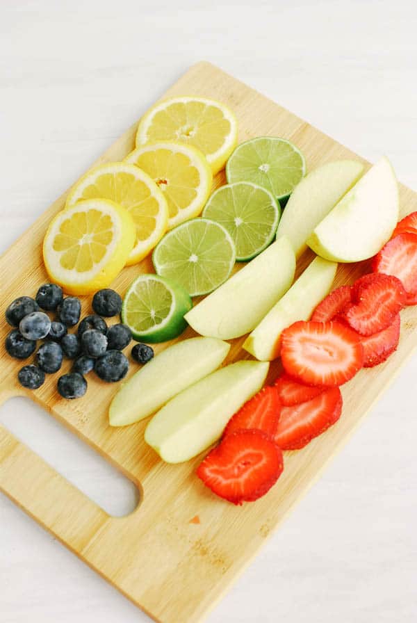 Fresh fruit cut up and laid out on a cutting board.