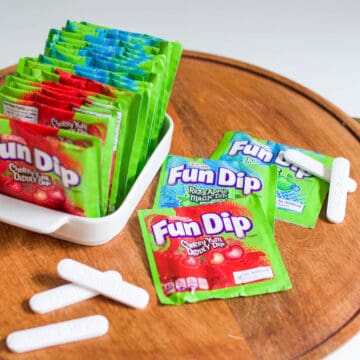 Close up of Fun Dip candy pouches next to white candy sticks on a tray.