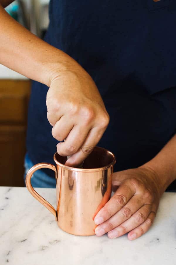 Muddling rosemary and blackberry for a halloween moscow mule.