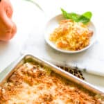 Pan of Pineapple Dump Cake next to a serving on a small white plate.