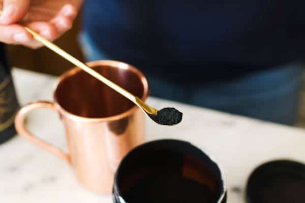 Adding coconut activated charcoal to drinks.