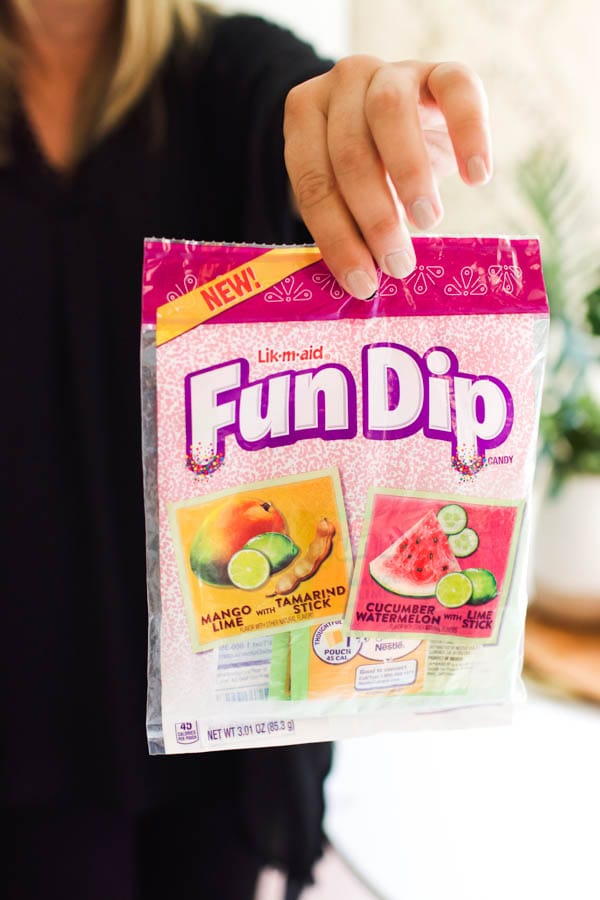 Fun Dip dulceria flavors being held by woman's hand.