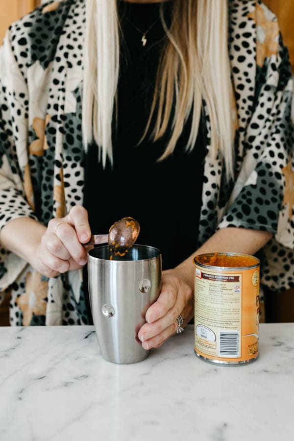 Adding pumpkin to a cocktail shaker.