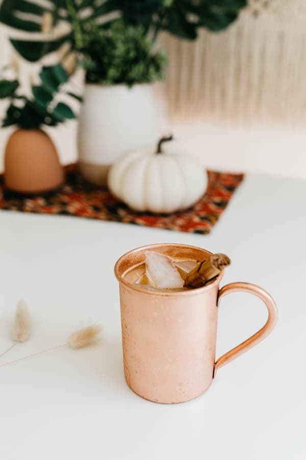 Pumpkin spice Moscow Mule on a table with fall decorations.