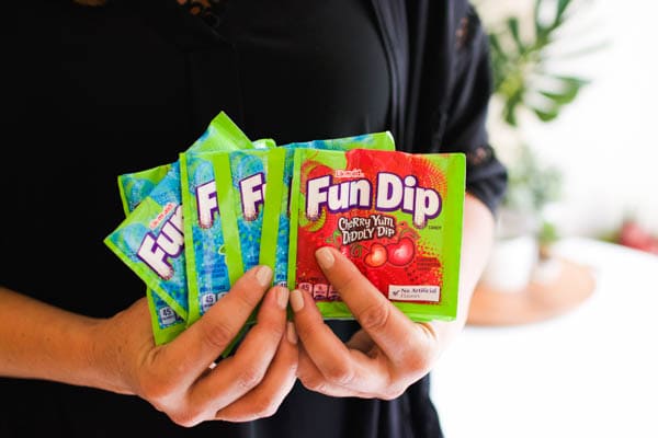 A woman holding packets of Fun Dip candy.