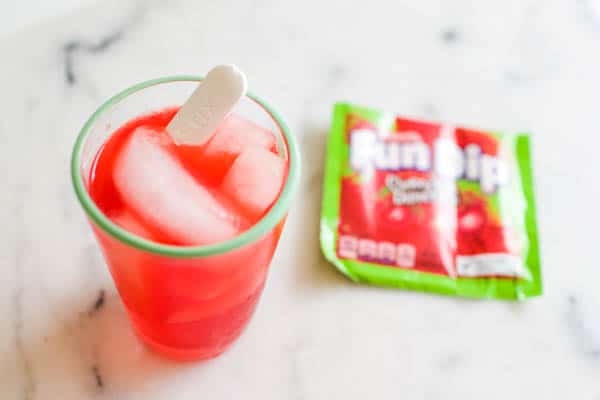A mocktail with fun dip candy in it and next to it. 