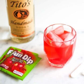 A Cherry Fun Dip cocktail in a glass on a table.