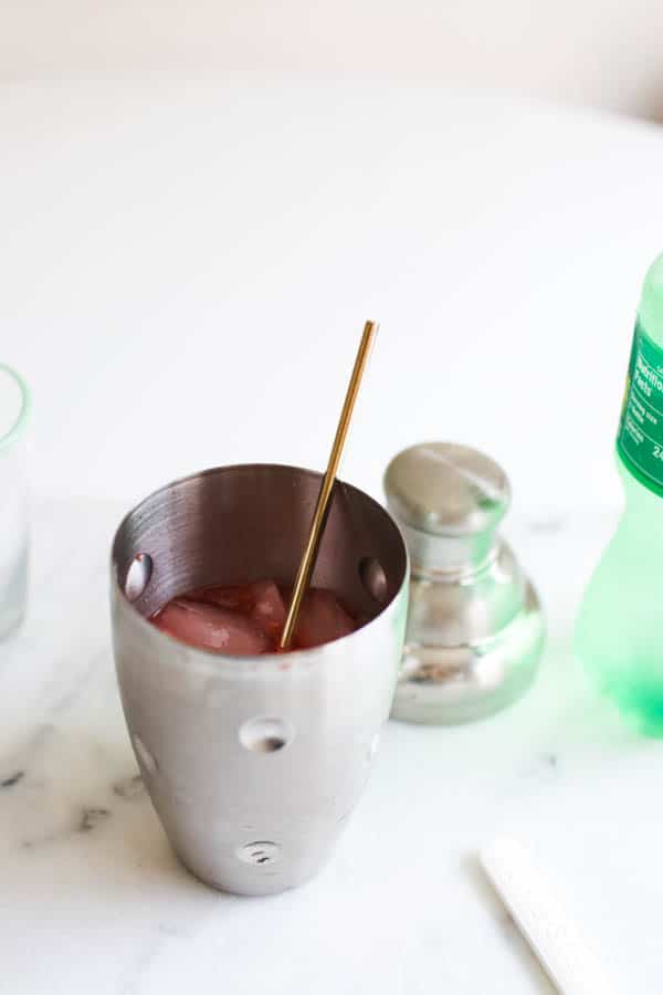 Cocktail shaker with Fun Dip drink ingredients with a bar spoon. 