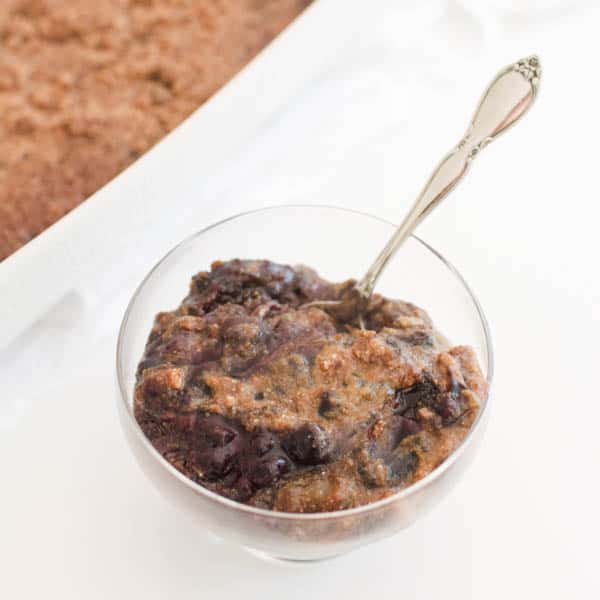 Gluten free blueberry dump cake in a small glass dessert bowl. 