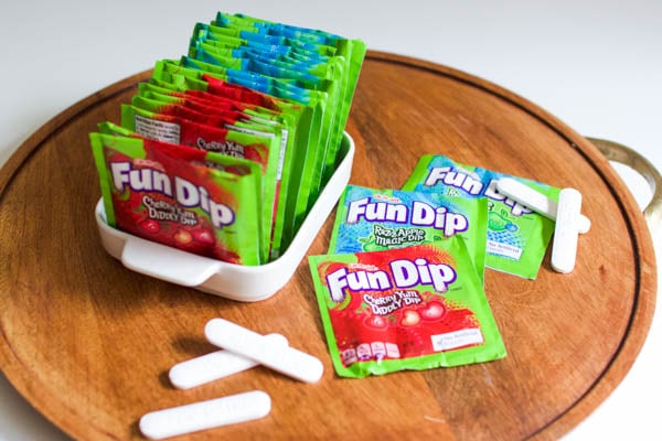 A bunch of packets of fun dip in a bowl and on a tray.