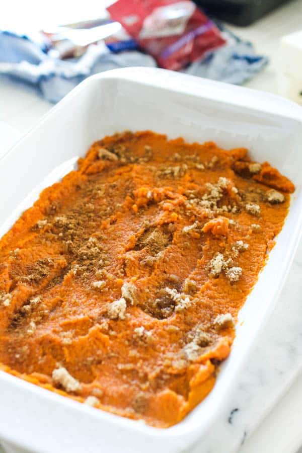 Baking dish with pumpkin and brown sugar in the bottom for a fall dessert recipe.