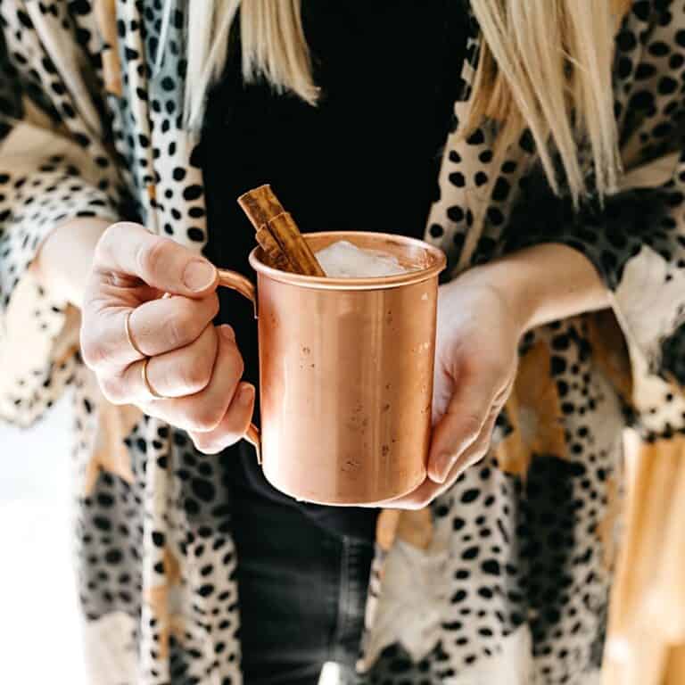 Woman holding a pumpkin spice moscow mule.