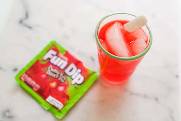 A close up of a cup with a non-alcoholic drink made with Fun Dip candy.