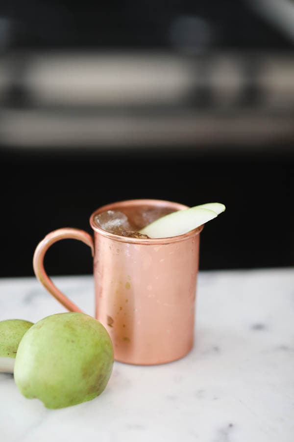Fall spiced pear mule on a cutting board with a pear next to it.
