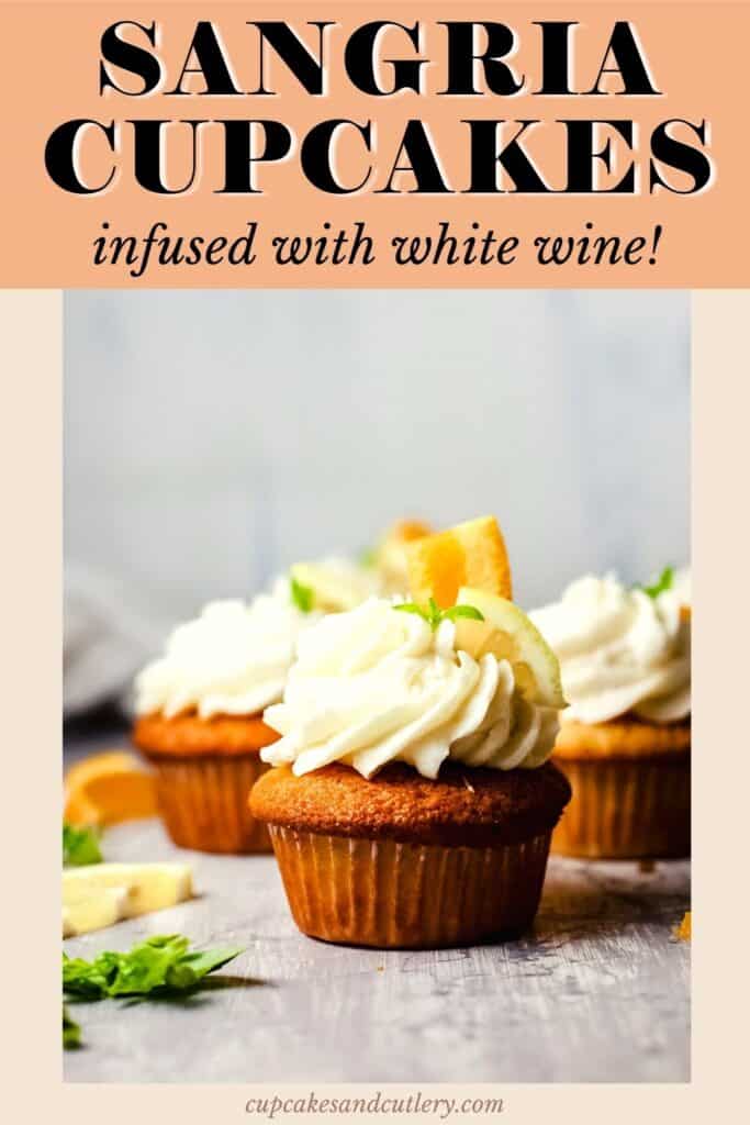 Close up of a side view of a frosted cupcake topped with a piece of lime and orange.