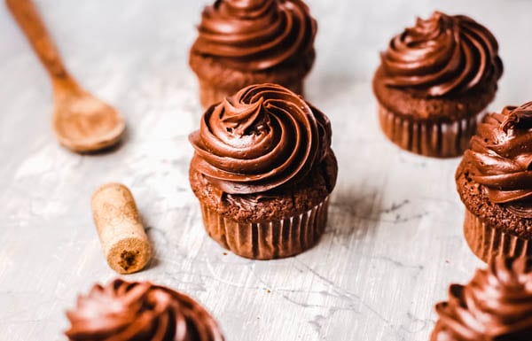Wine infused cupcakes with chocolate frosting on a grey background.