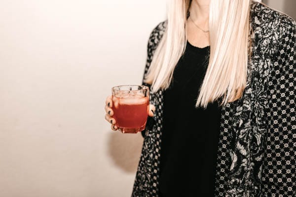 woman at a holiday party holding a cocktail