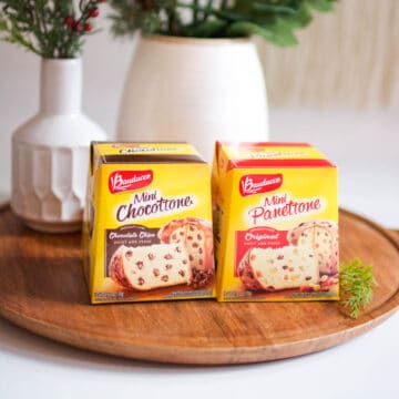 Two yellow boxes of Panettone on a tray on a table.