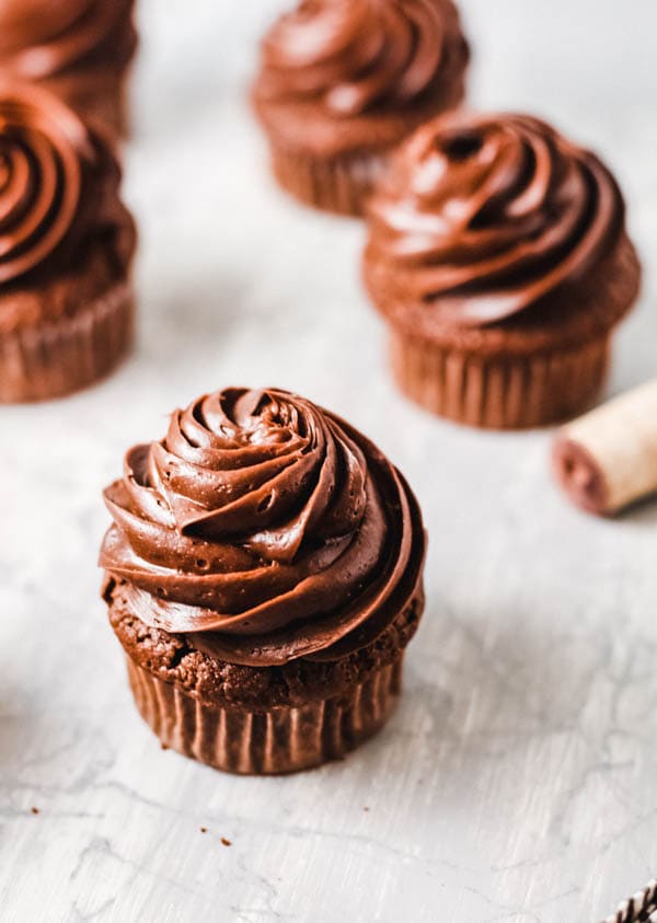 Frosted boozy chocolate cupcakes on a table. 