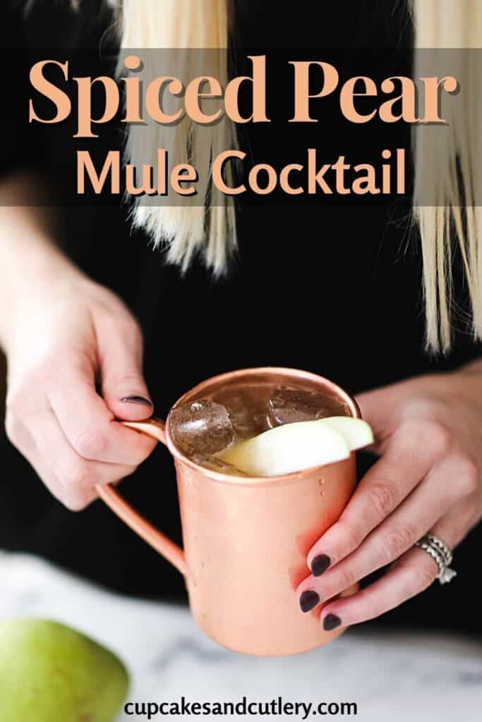 Woman holding a spiced pear mule cocktail.