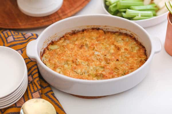 hot artichoke dip in a baking dish on a table