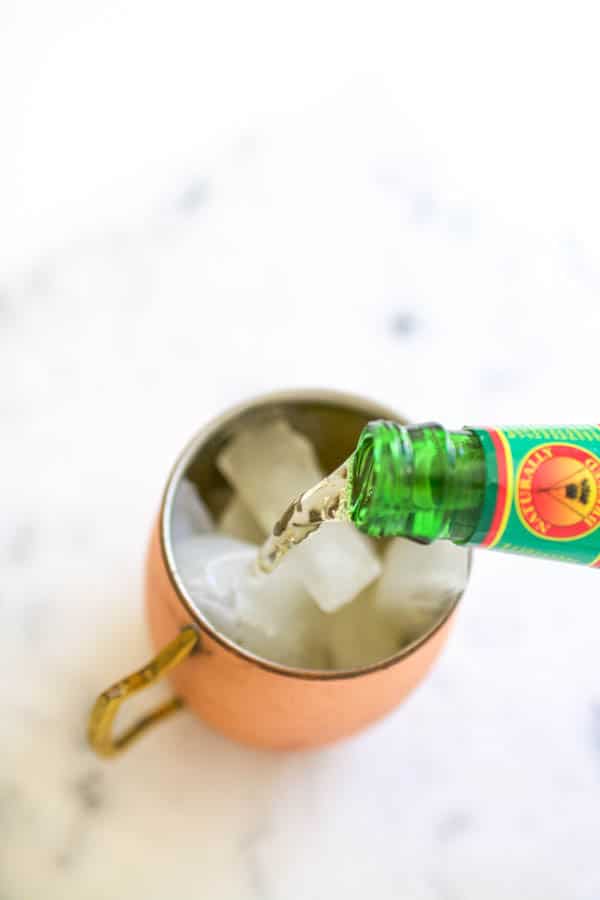 pouring ginger beer into a moscow mule mimosa