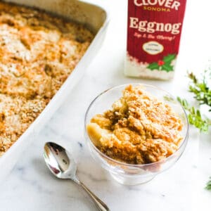 A small glass dish holding a portion of eggnog dump cake next to the rest of the pan.