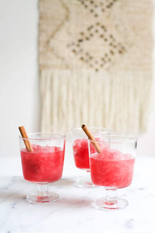 3 glasses of Cranberry Vodka Slush with a cinnamon stick garnish. 