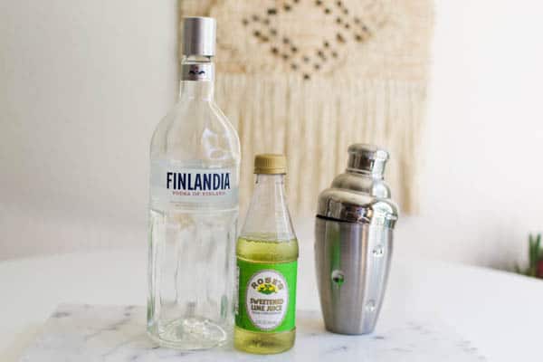 Ingredients for a vodka gimlet on a table.