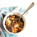 Close up of a bread and butter pudding in a bowl with chocolate.