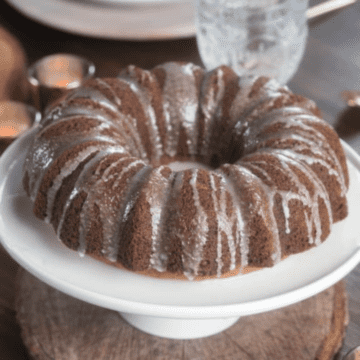 Icing glazed Nutmeg bundt cake on a white cake plate.