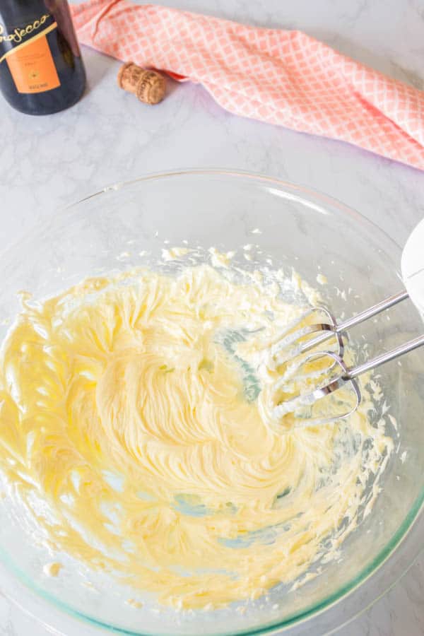 Using a hand mixer to make prosecco buttercream.