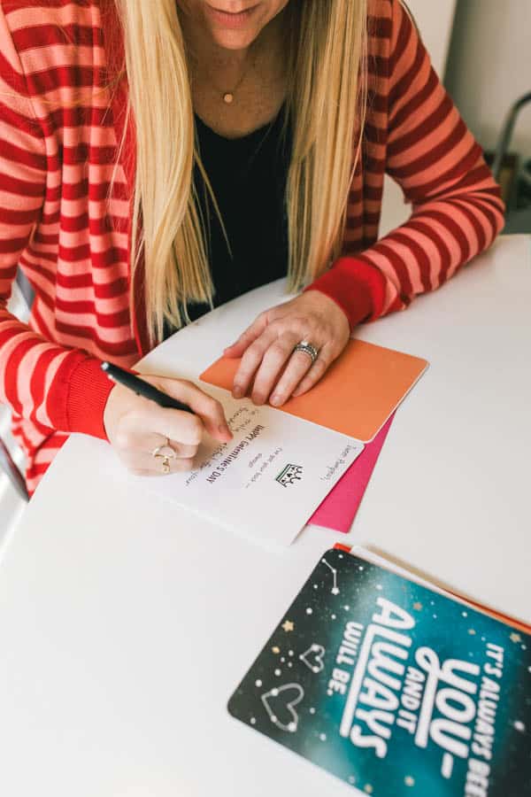 Woman writing in a greeting card.