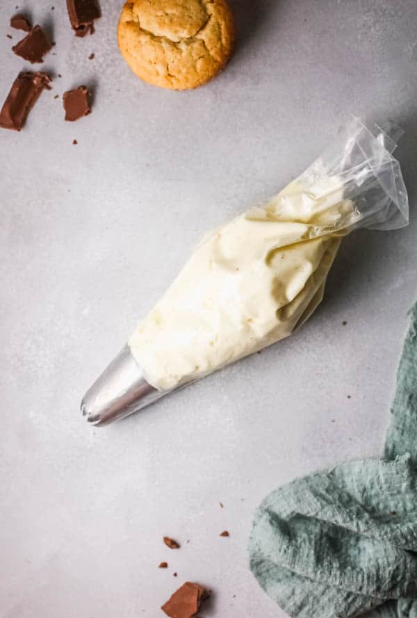 White Russian buttercream in a piping bag on a table.