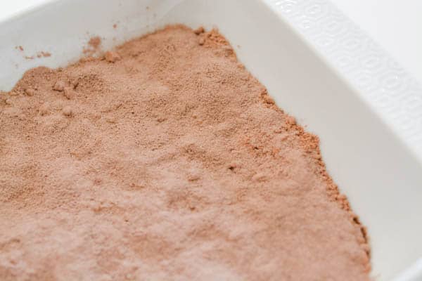 Dry chocolate cake mix and pudding in a dish for a dump cake.