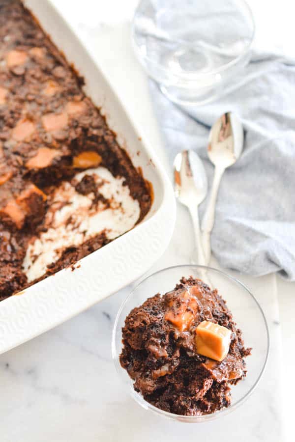 Chocolate Caramel dump cake in a serving pan and a glass dessert bowl.