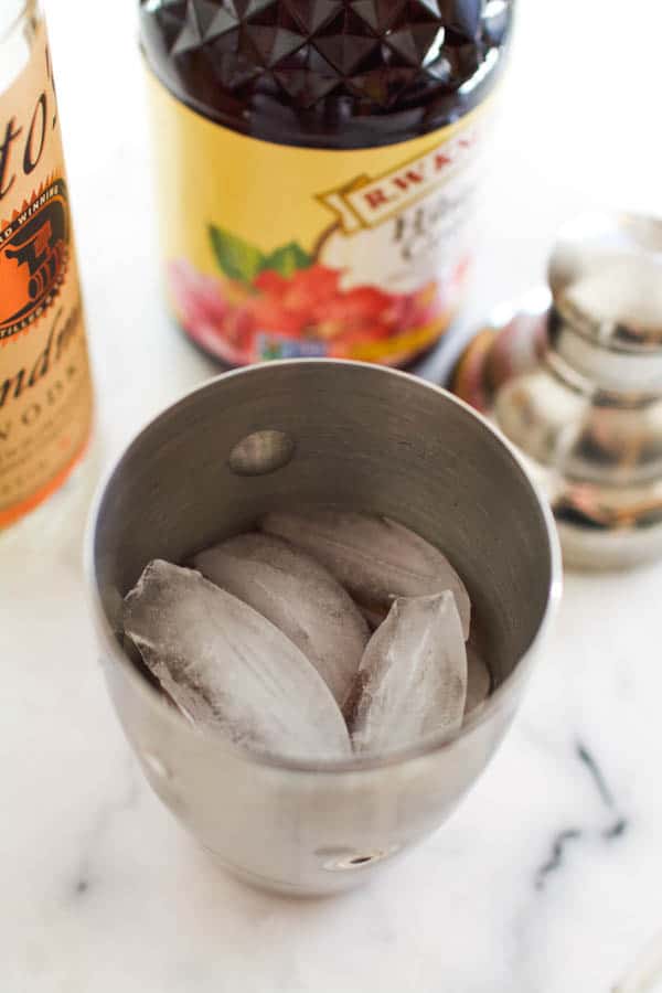 Cocktail shaker with hibiscus liqueur, vodka and ice in a cocktail shaker for an easy cocktail.