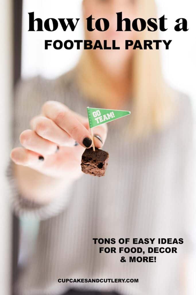 Woman holding a brownie bite with a tiny football flag toothpick in it.