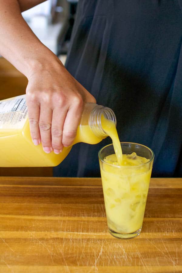 adding orange juice to a glass